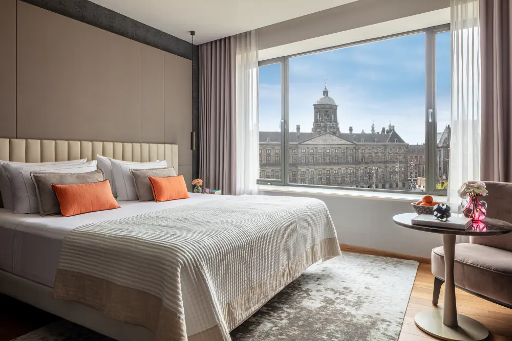 Hotelkamer met tweepersoonsbed en uitzicht op het Koninklijk Paleis