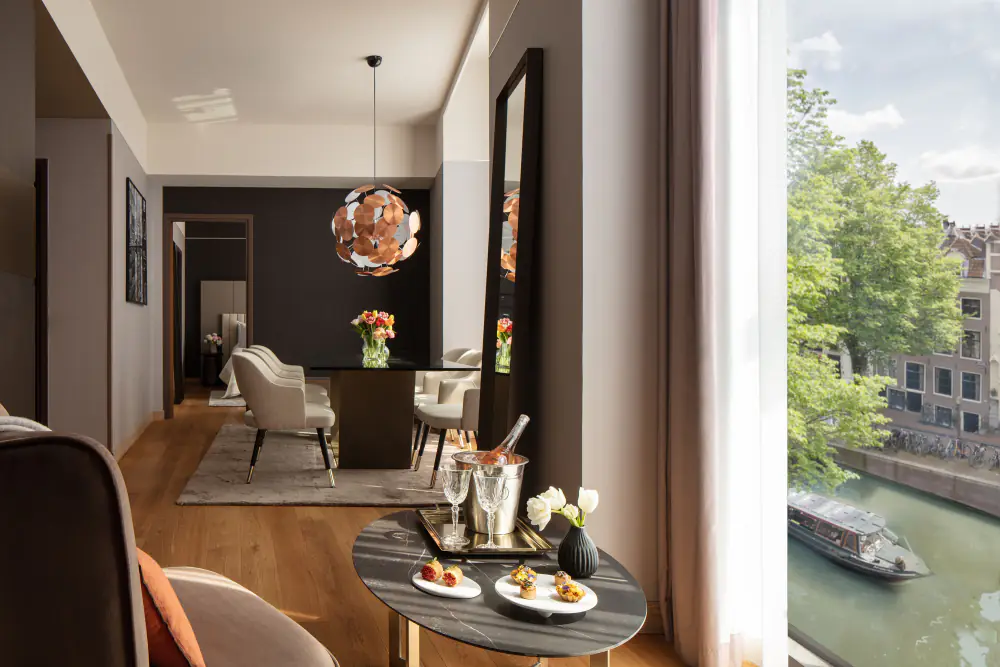 Zitgedeelte van een suite met eettafel en hanglamp