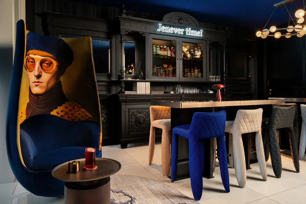 Een donkerblauwe tafel en stoel in Prins & Aap voor het Jenever Hour, met een portret aan de wand