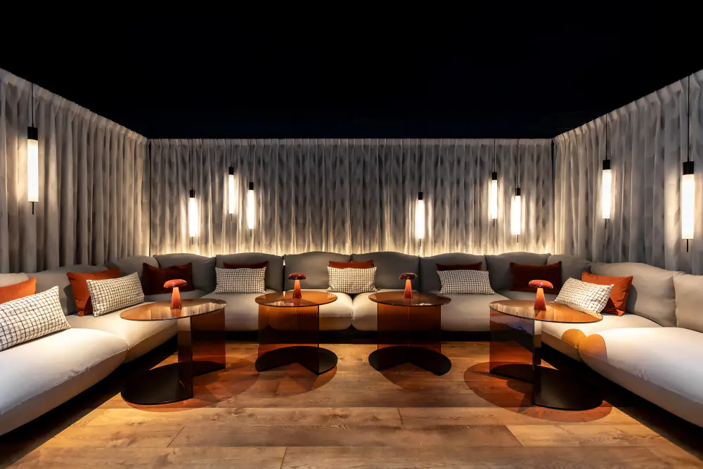 Een lounge in Prins & Aap met lage banken langs de wand en zachte verlichting