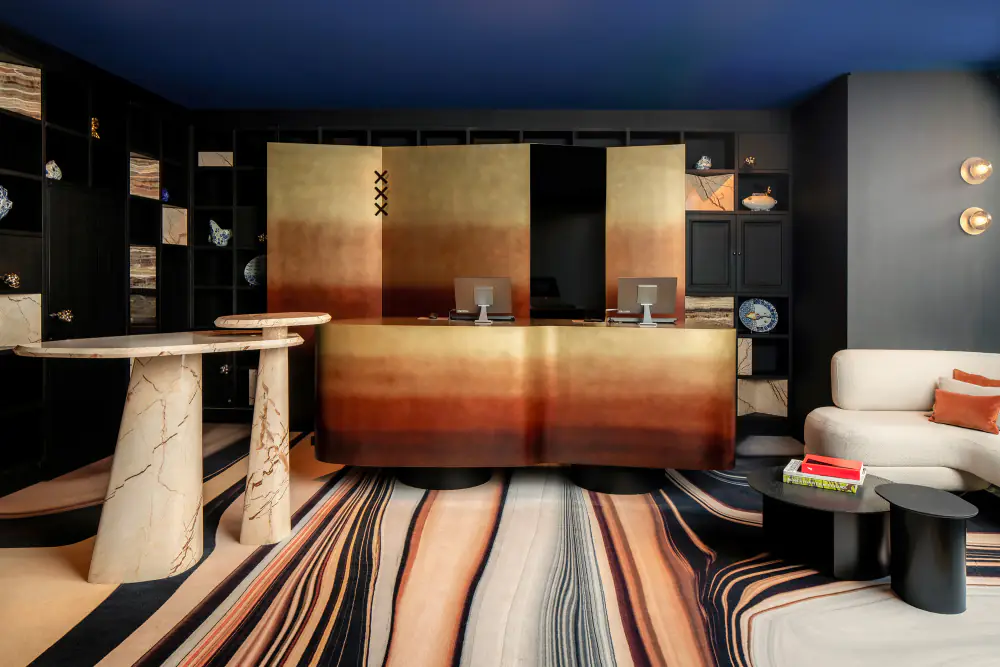 De receptie van Andaz met gouden panelen en een gestreept tapijt