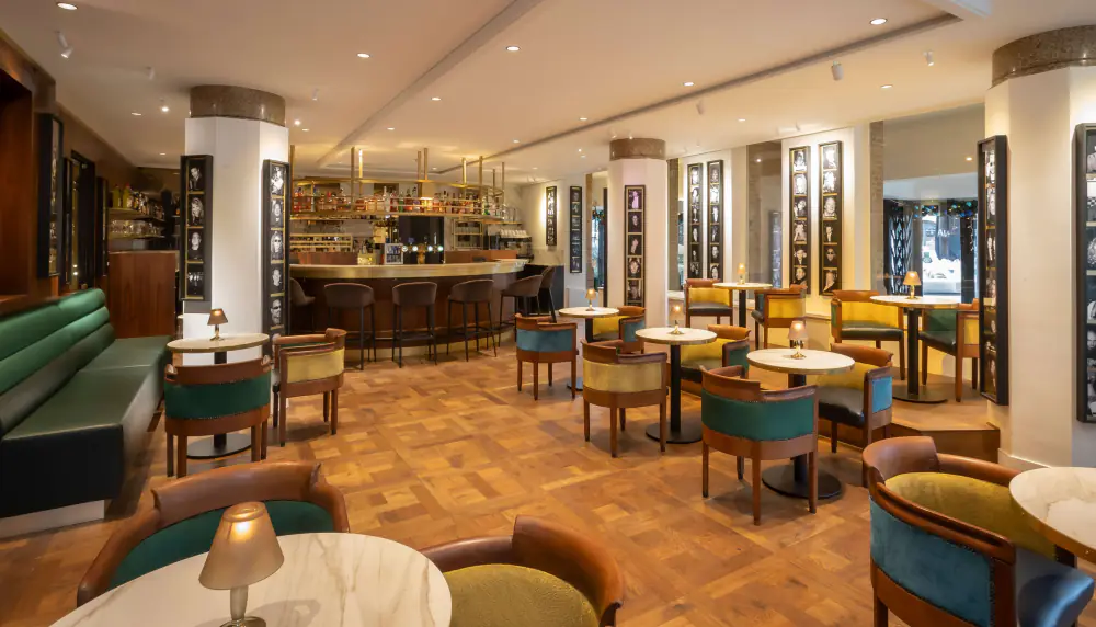 Bar Americain met leren banken, lage tafels en een lange bar onder sierlijke lampen