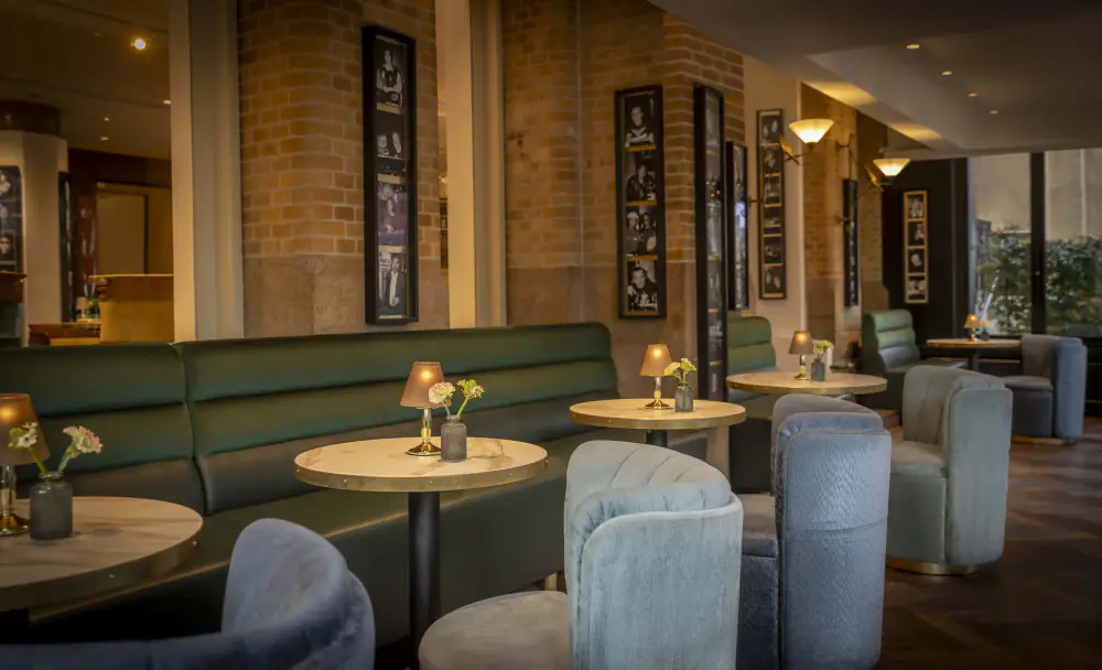 Ronde tafels en fluwelen stoelen in Bar Americain