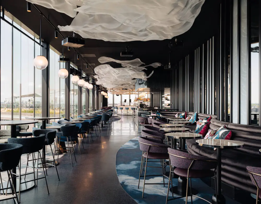 De bar van LuminAir met grote ramen en uitzicht over de stad