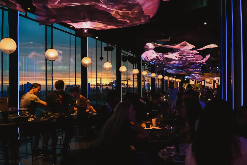 Tafels in LuminAir bij de ramen, met de stad op de achtergrond