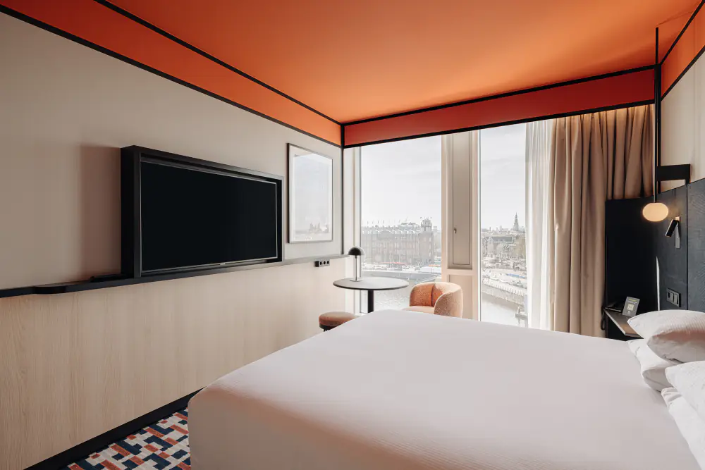 Een hotelkamer van DoubleTree met een bed bij grote ramen en uitzicht over het water
