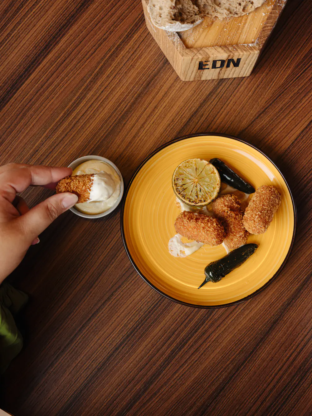 Een gerecht van WE ARE EDN op een gele tafel