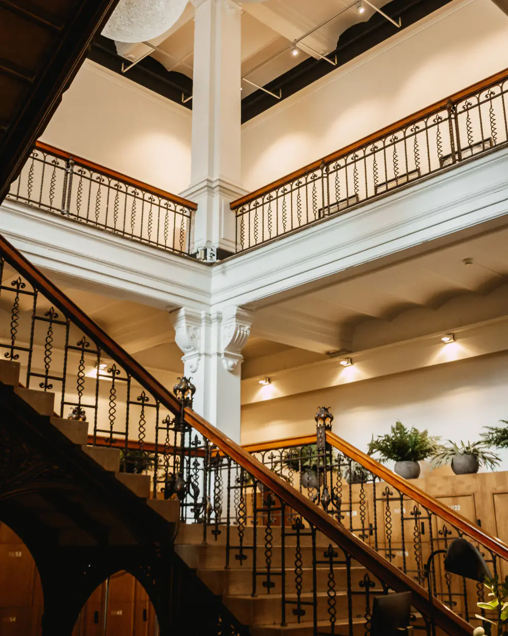 De hoge hal van Hotel Arena met een houten trap en galerijen