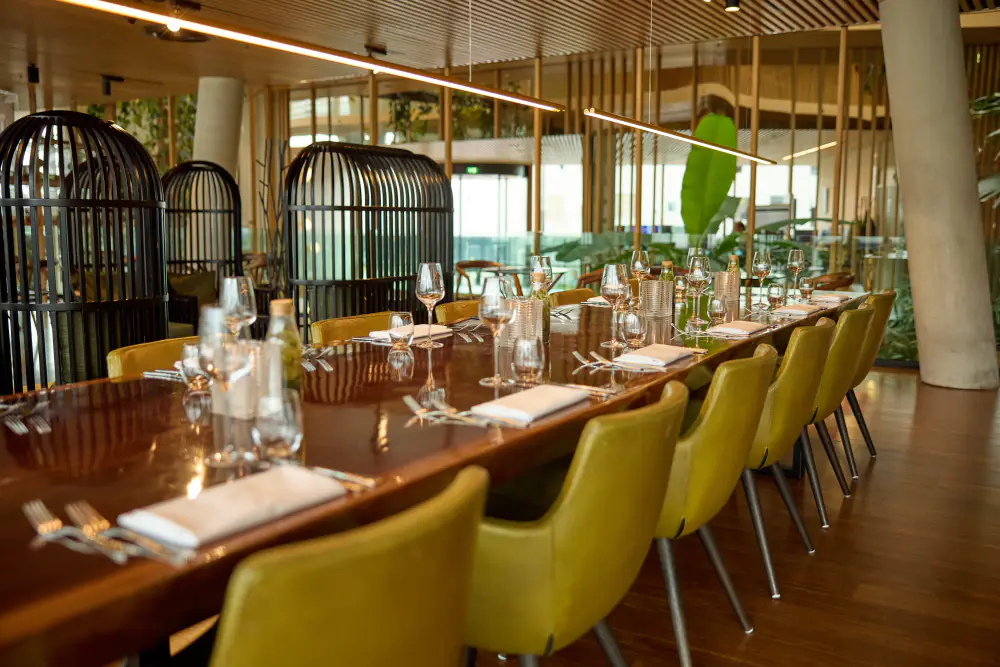 De zaal van Café Jakarta met lange tafels en grote ramen