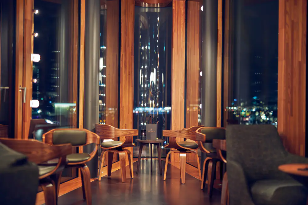 Zitjes bij de ramen van Skybar Malabar, met uitzicht over het IJ bij avond