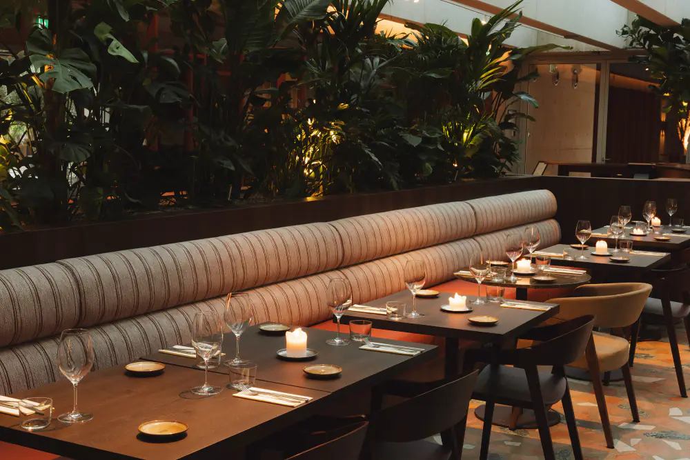 Het overdekte terras van Orchid House met tafels en planten