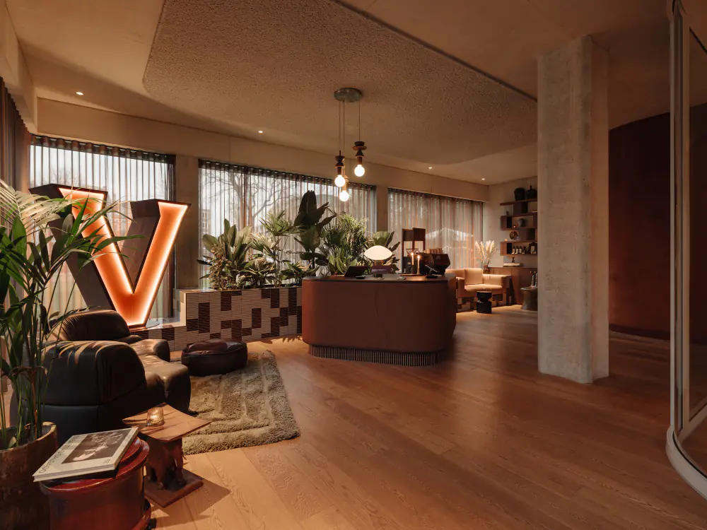 De lobby van Hotel V Oosterpark met een grote verlichte V en planten