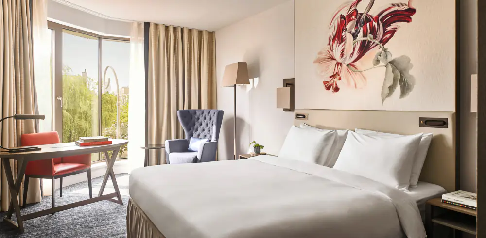 Een hotelkamer van Hyatt Regency met een bed en een grote bloemenprint aan de wand