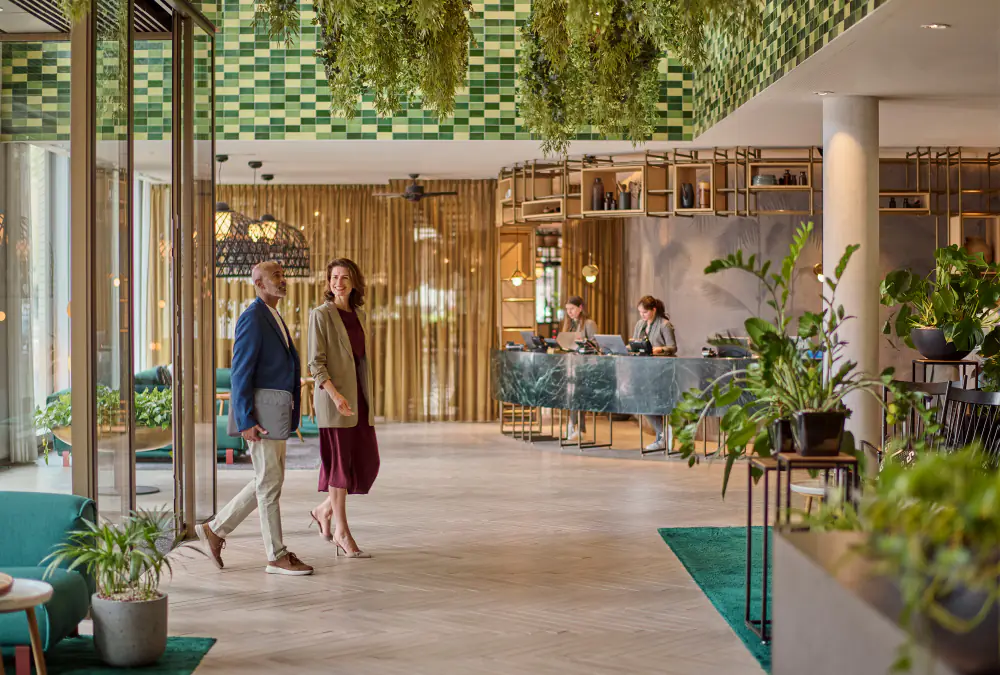 De lobby van Hyatt Regency met planten aan het plafond en gasten die binnenlopen