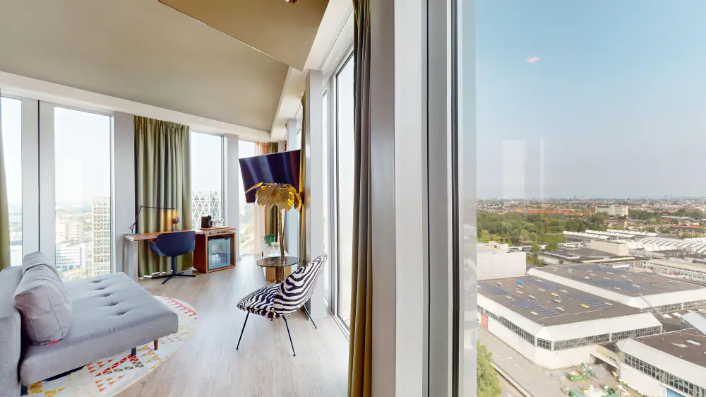 Een kamer van nhow met grote ramen en uitzicht over Amsterdam-Zuid