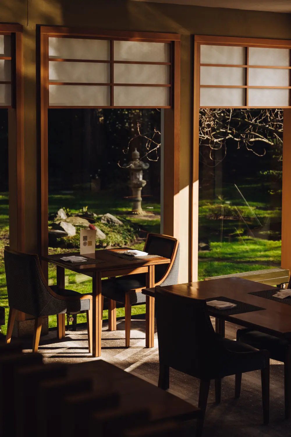 Een tafel van KIRI bij het raam, met uitzicht op de Japanse tuin