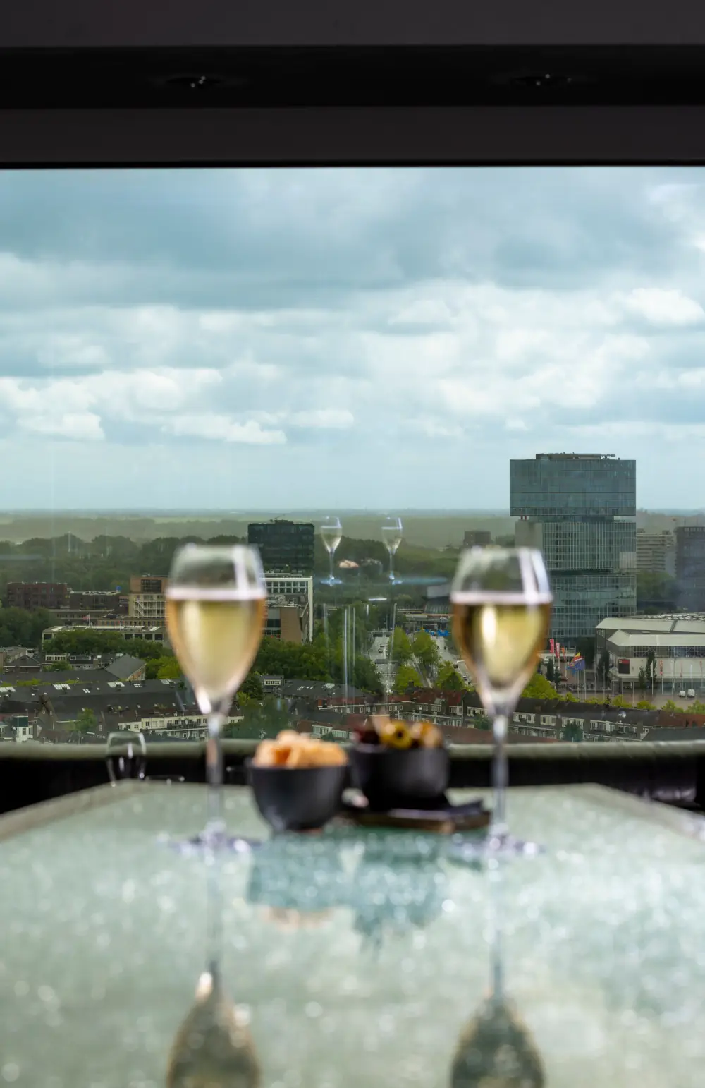 Twee glazen aan het raam van Twenty Third Bar, hoog boven de stad