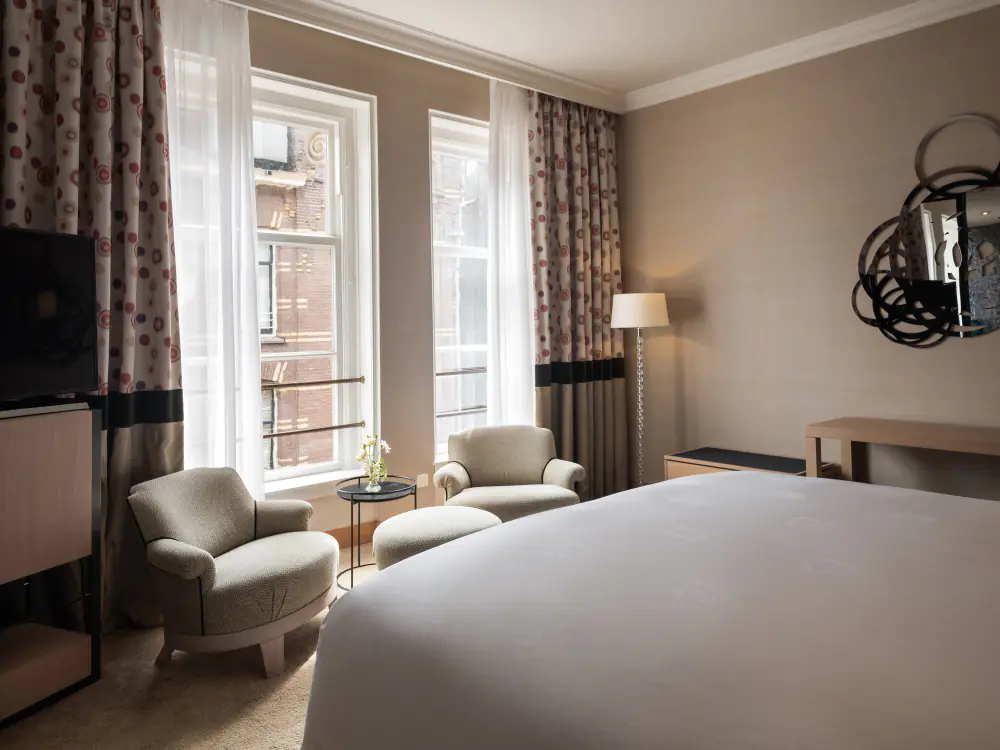 Een suite van The Grand met een zithoek bij hoge ramen