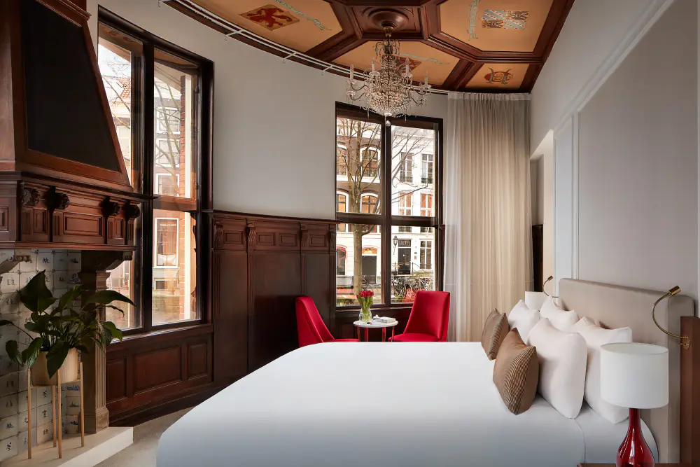 Een suite van Tivoli Doelen met een houten lambrisering, een beschilderd plafond en rode stoelen bij het raam