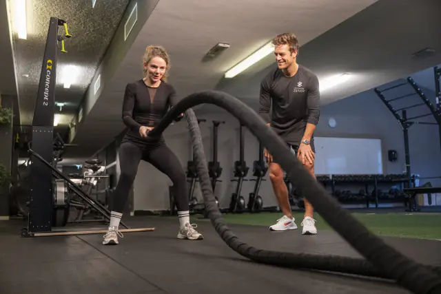 Twee mensen trainen met battle ropes in de sportzaal van Fitness Zuiver