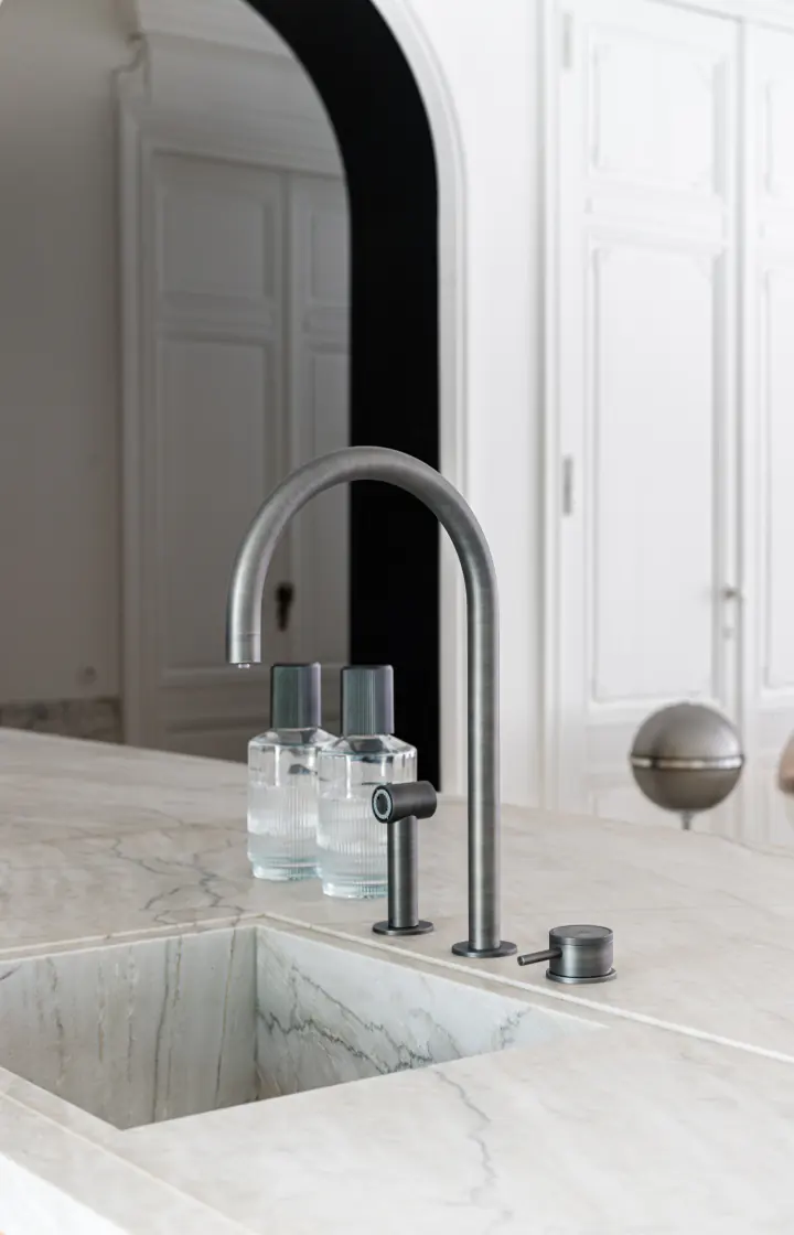 Close-up of the tap, the controls and the marble sink