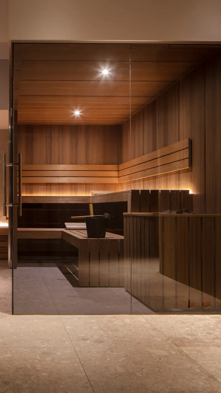 Sauna en stoomcabine achter glas in de Anantara Spa in Amsterdam centrum, met warm licht op de houten banken