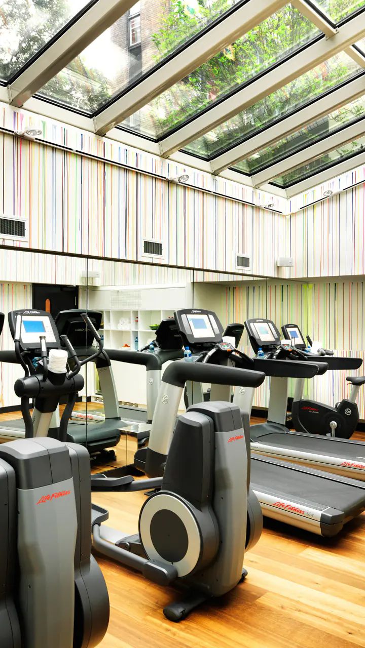 Het fitnesscentrum van Andaz met loopbanden en toestellen onder een glazen dak