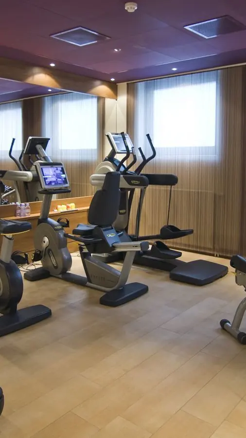Fitnessruimte van Sofitel met loopbanden, toestellen en ramen