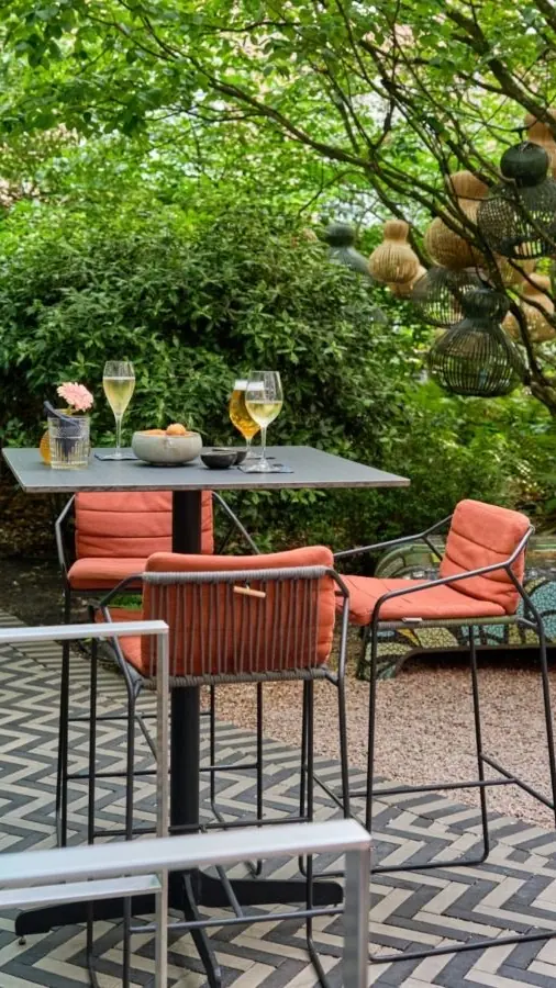 De Garden Terrace in de binnentuin van The Grand, met oranje kussens en veel groen