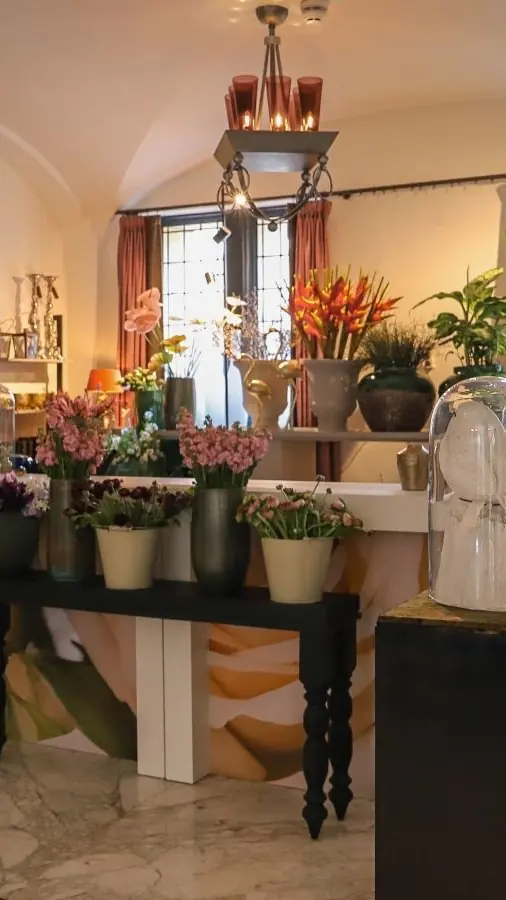 De Library ‘Or’ met fauteuils, een tafel met bloemen en lichte wanden