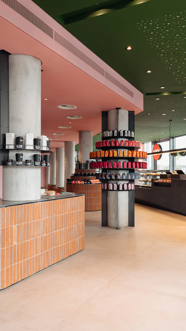 Koffiebar LOT61 met groene letters aan de wand, banken en lage tafels