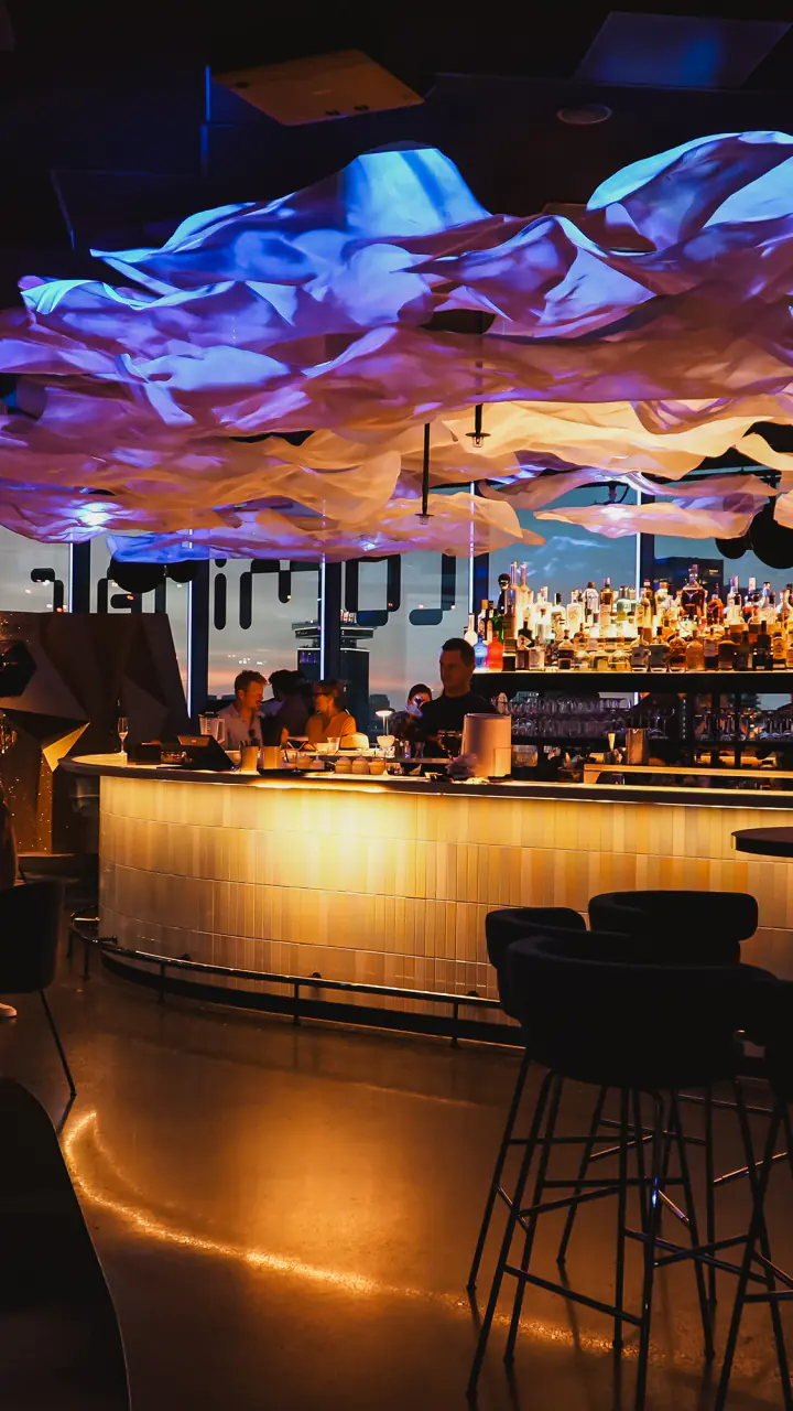 LuminAir bij avond, met een verlichte bar onder een kleurrijk plafond