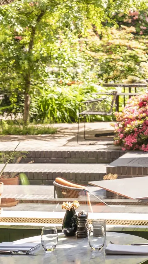 Oriole Garden Bistro met groene stoelen en planten bij een trap naar de tuin