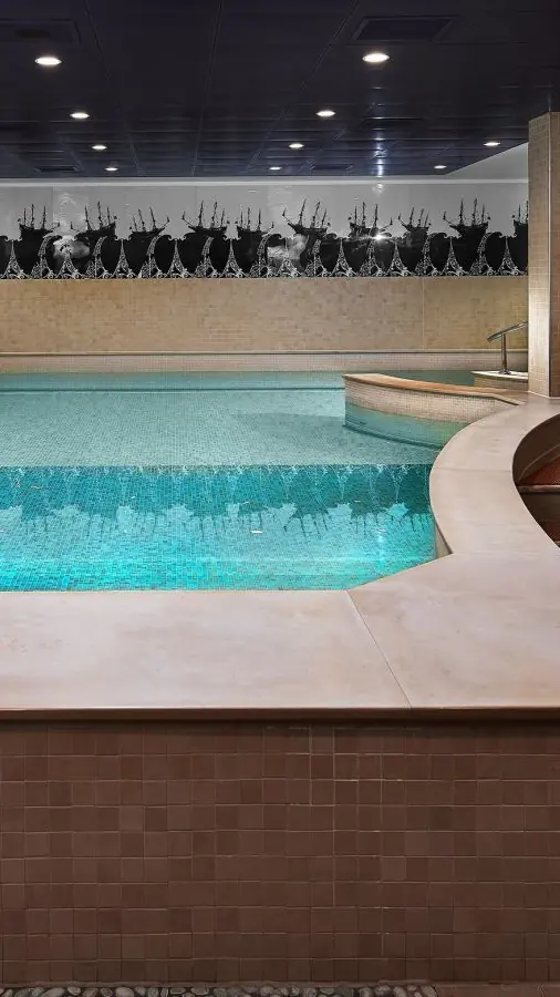 Het verwarmde binnenzwembad van de Sofitel SPA met ligbedden