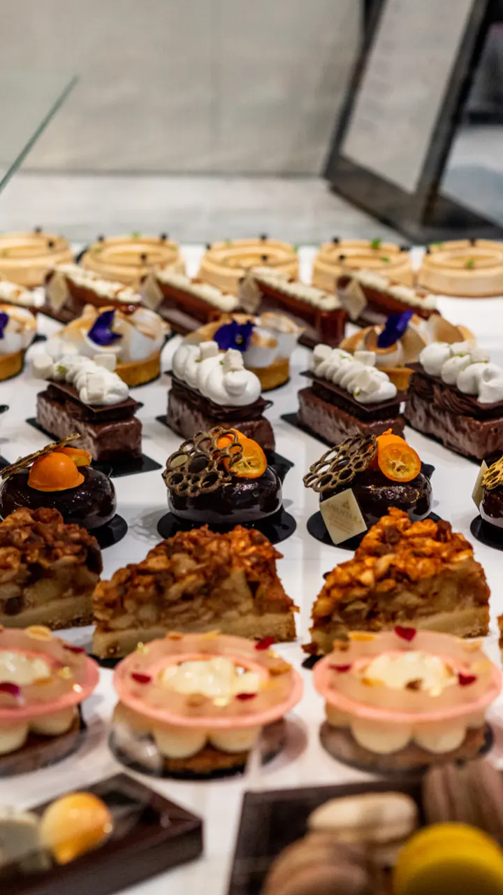 Een vitrine in The Cake Room vol taartjes, eclairs en ander gebak
