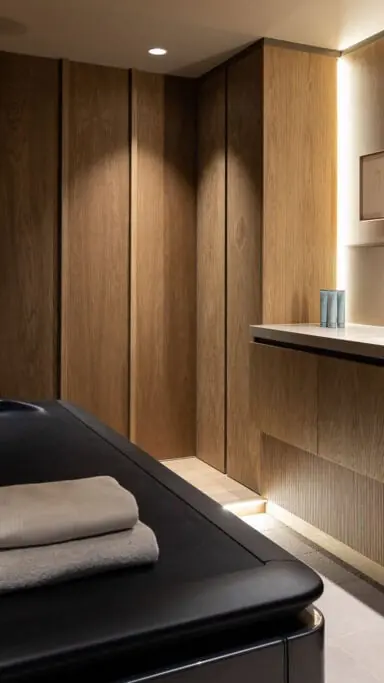 Behandelkamer van Urban Spa met een behandeltafel, handdoeken en houten wanden